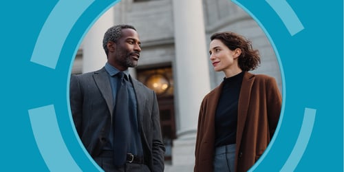 Two legal professionals stand outside a courthouse